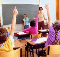 Children with raised hands in classroom